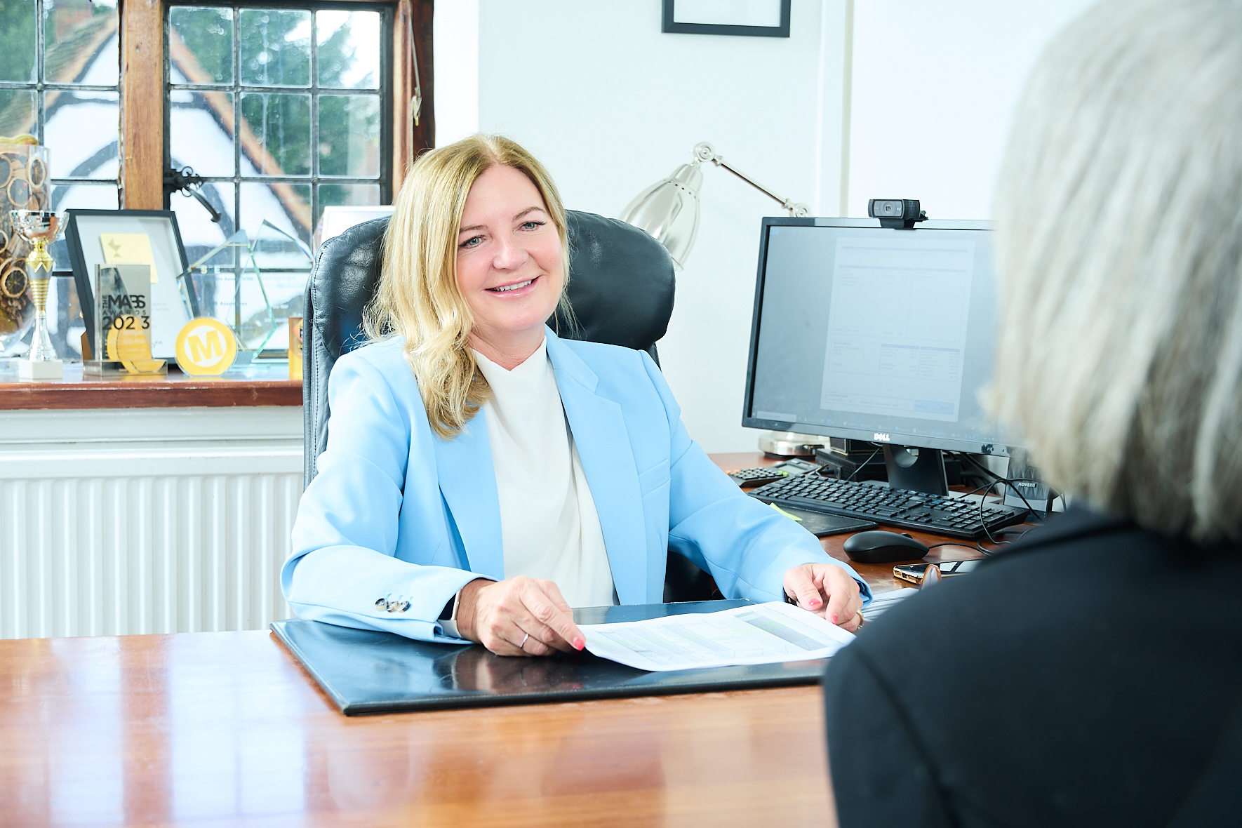 Woman at a desk having a discussion with a client.